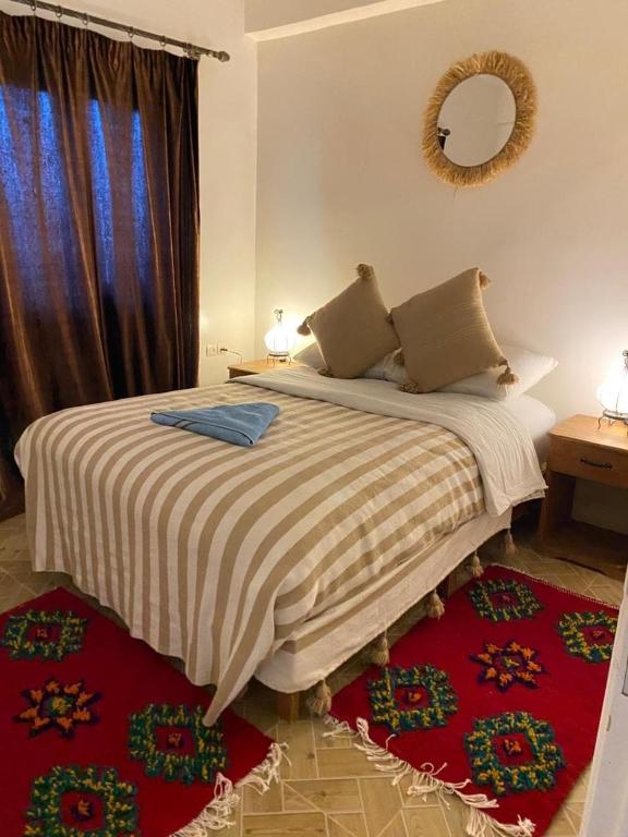 a bedroom with a large bed with a mirror on the wall at Appartement of Habiba in Essaouira