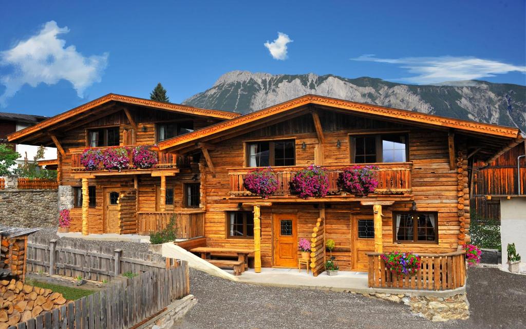 une cabane en rondins avec des boîtes de fleurs à l'avant dans l'établissement Resort Alt-Ötztal, à Sautens