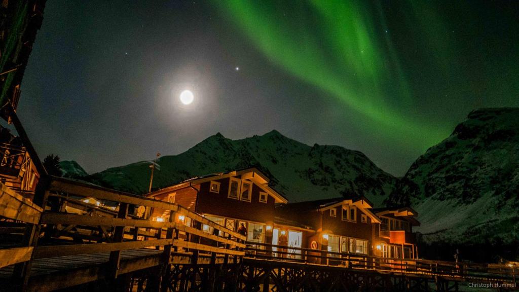 an image of a house with the aurora in the sky at Koppangen Brygger in Koppangen