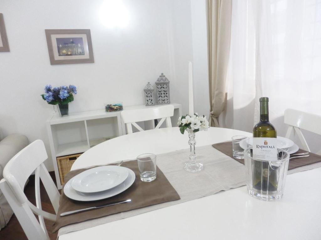 a white dining room table with a bottle of wine at Casa Vacanze Ricordi Romani in Rome
