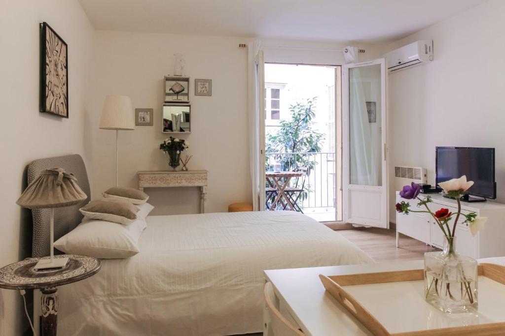 a white bedroom with a bed and a television at Studio Chateau - Vieux Nice in Nice