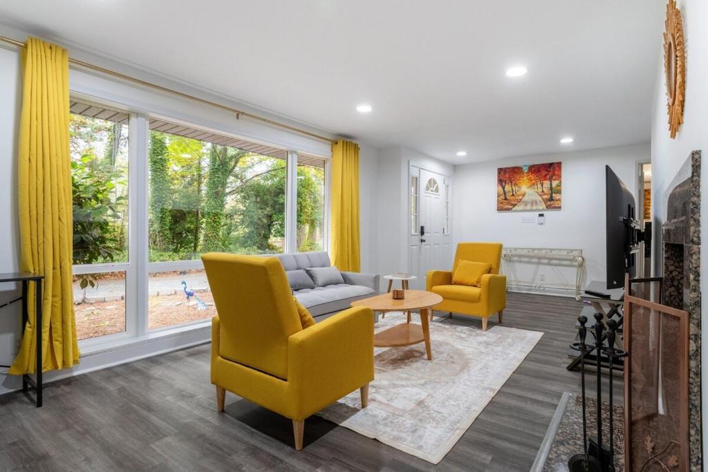 ein Wohnzimmer mit gelben Stühlen und einer Couch in der Unterkunft Rina's yellow house in Sammamish