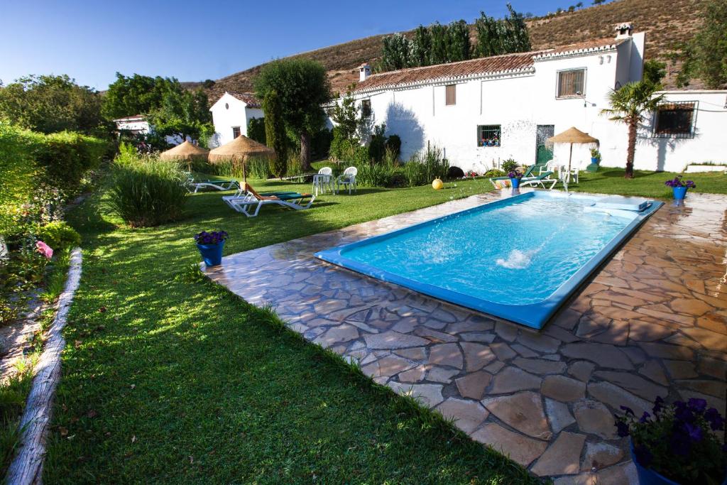 a swimming pool in the yard of a house at Al Agia - Los Molinos de Padul in Padul