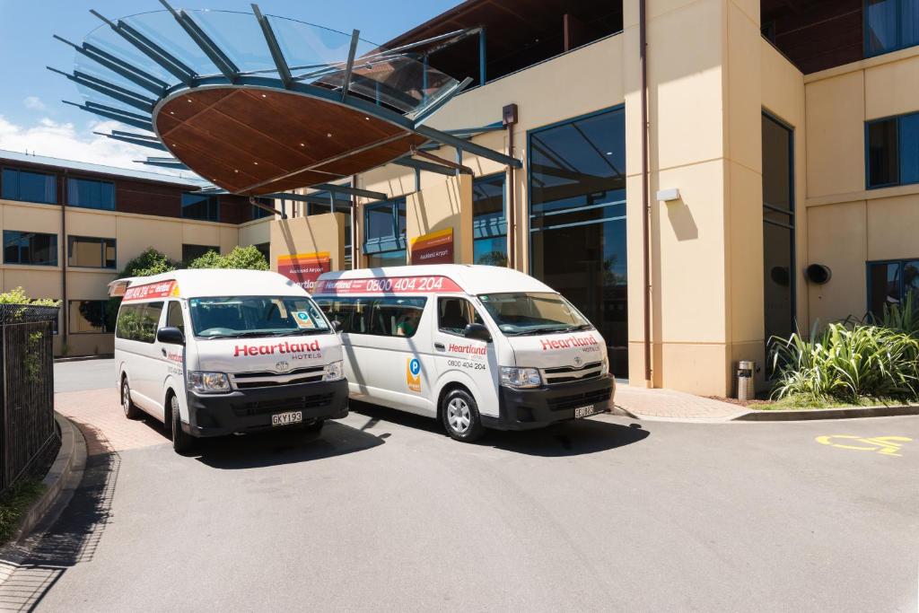 two vans parked in front of a building at Heartland Hotel Auckland Airport in Auckland