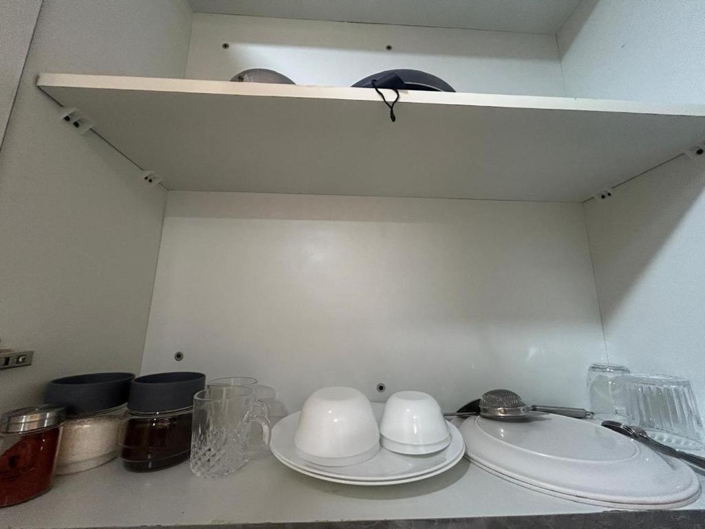 a kitchen counter with plates and bowls on a shelf at Luxury Stay by Good vibes studio in Ghaziabad