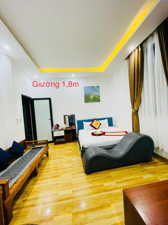 a room with two beds and a couch in it at SAPHIA Hotel Hue in Hue