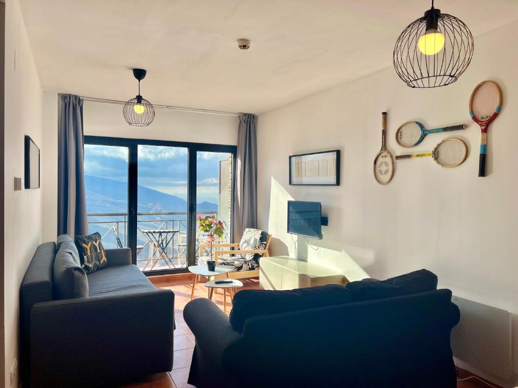 Una sala de estar con un sofá azul y una mesa. en SN Vista Nevada Suites, en Sierra Nevada