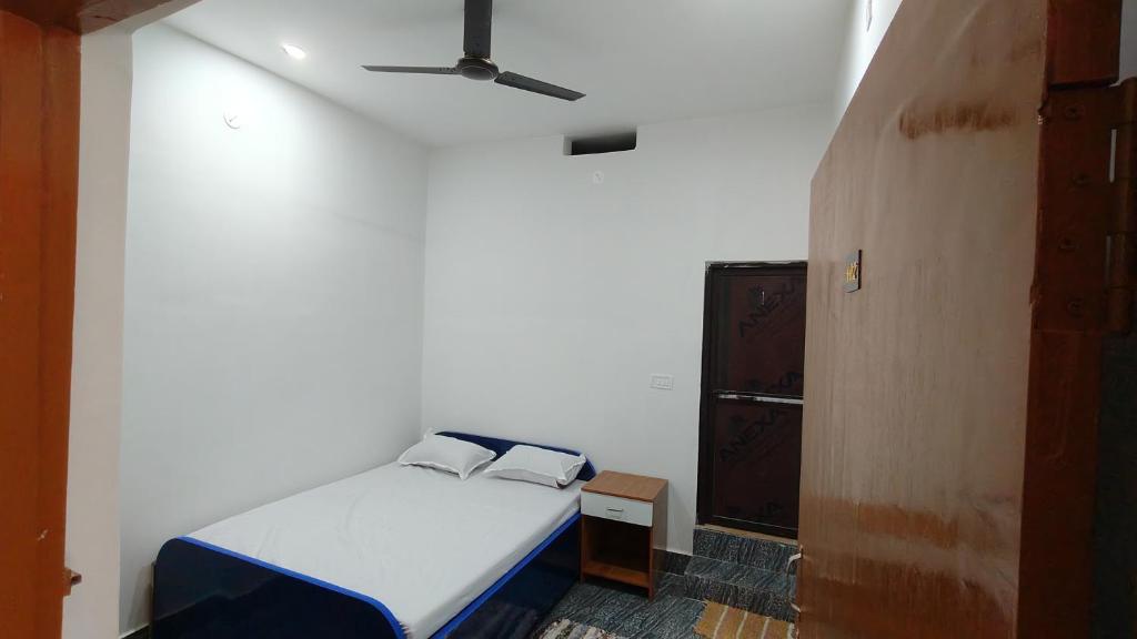 una camera da letto con un letto e un ventilatore a soffitto di Hotel M P Anand Palace a Gaya