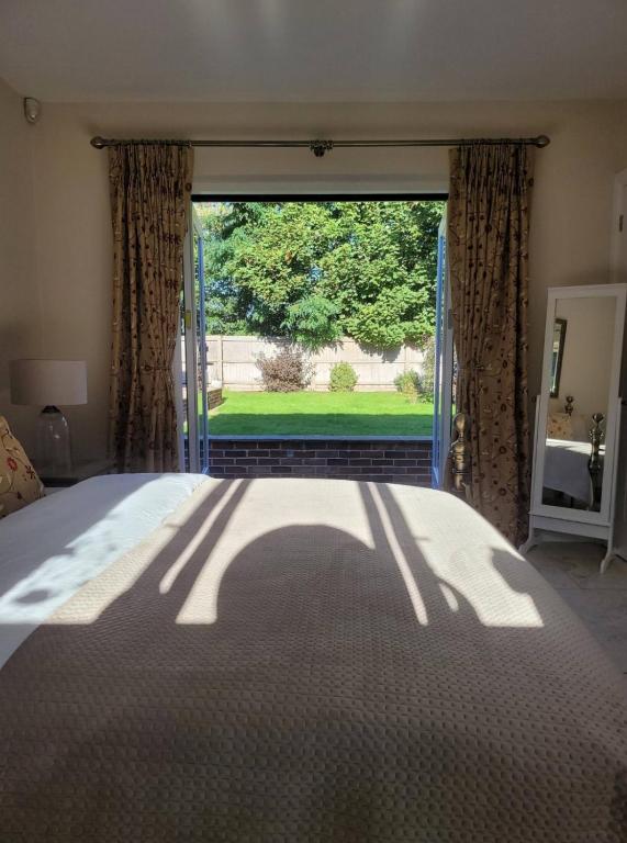 a bedroom with a bed and a large window at Beautiful garden room in Red Lodge