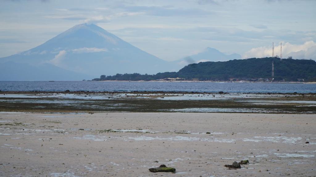 a mountain in the distance with a beach and the ocean at Mola2 Resort Gili Air in Gili Islands