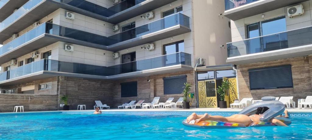 a couple on an inner tube in the swimming pool of a hotel at The ideal place by the sea Mamaia Nord Lidl area in Mamaia Nord