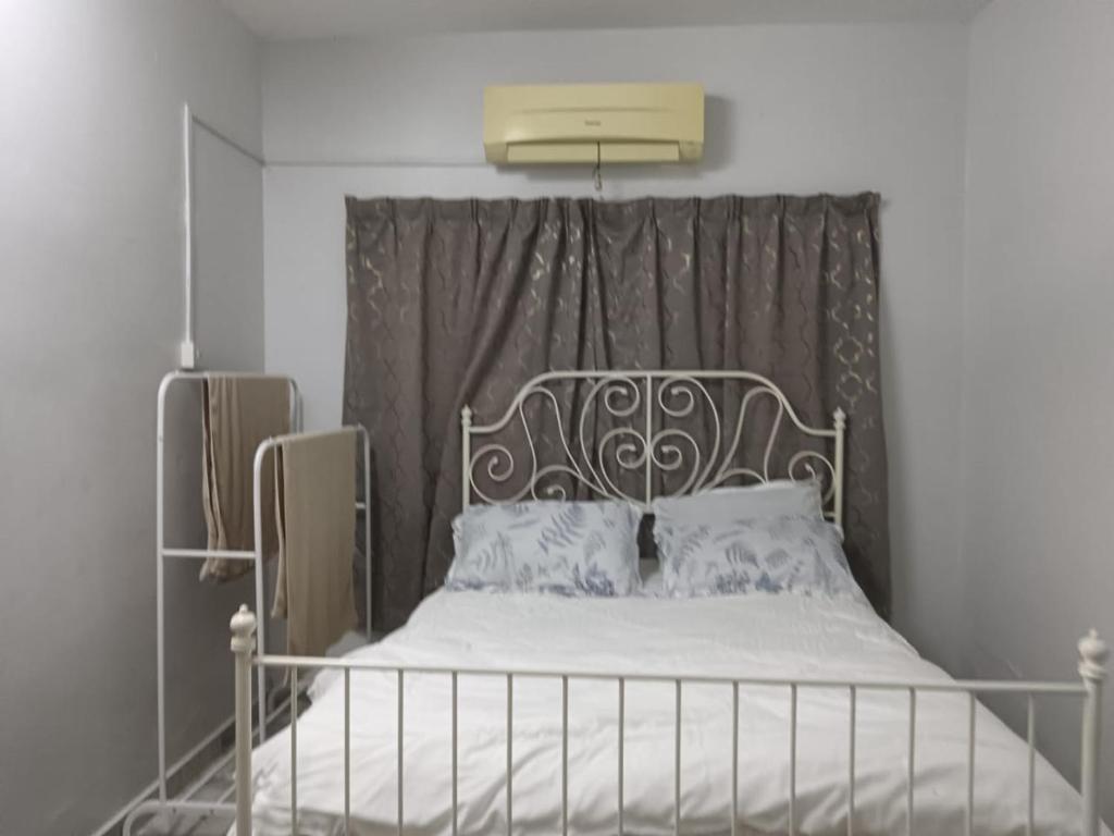 a bedroom with a bed with a metal headboard at Homestay Samera in Klang