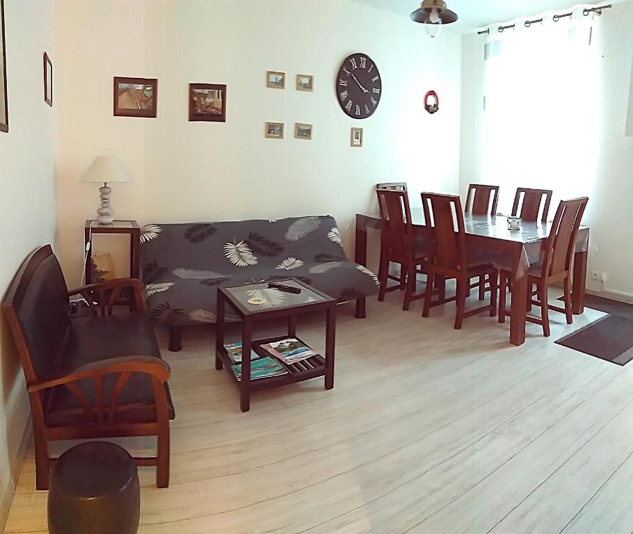 salon z kanapą, stołem i krzesłami w obiekcie Gîte Escale en vue - 3 Chambres - 150 m de la plage - w mieście Fécamp