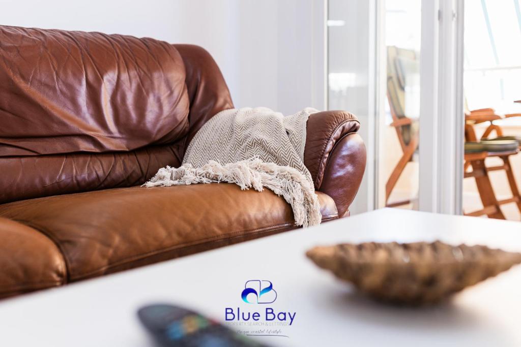 una silla de cuero marrón con un tazón sobre una mesa en White Bay Beach Apartment, en La Herradura