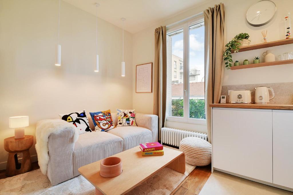 una sala de estar con un sofá y una mesa en Lovely Studio, en Boulogne-Billancourt