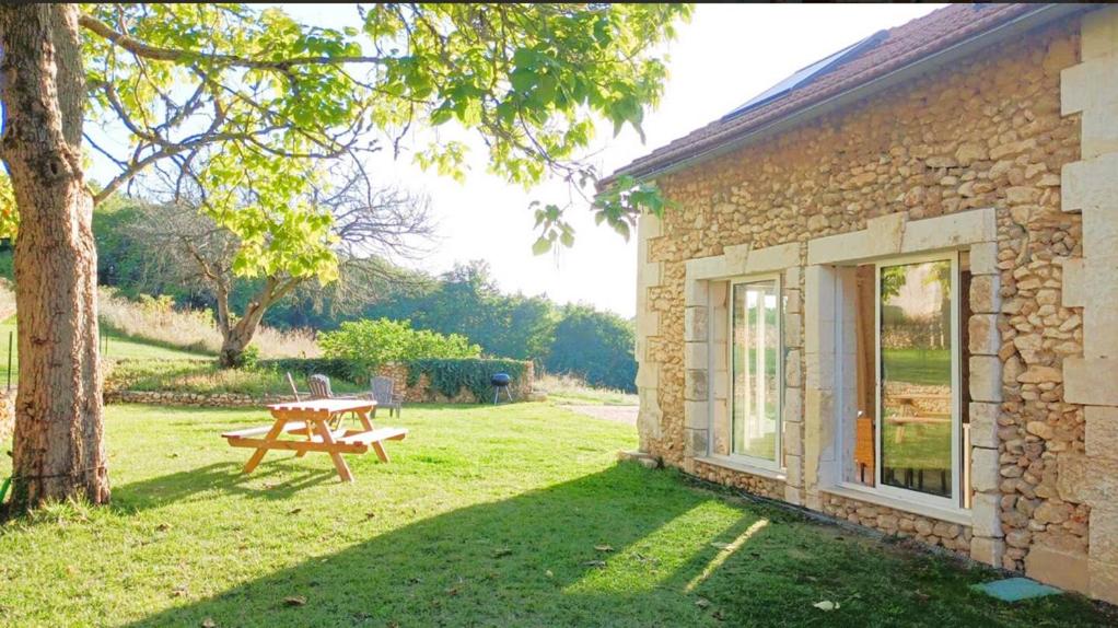 a picnic table in a yard next to a building at Le Cottage Brantôme in Bourrou
