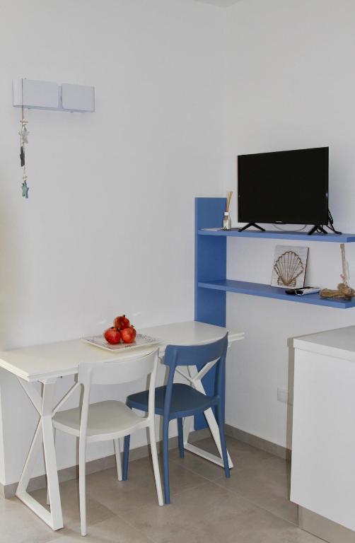 a dining room with a table and chairs and a tv at Marina29- Appartamento C in Castelsardo