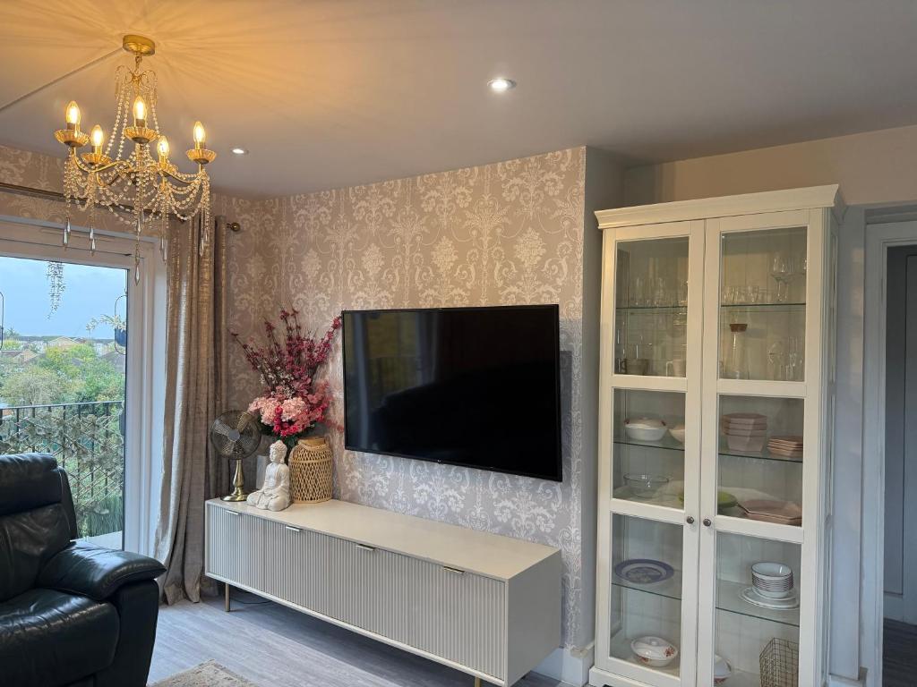 a living room with a tv and a entertainment center at Luxury Spacious Flat close to Central London in London