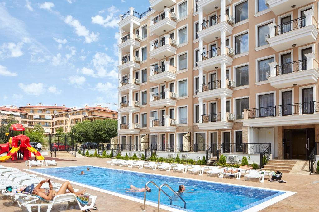 a pool in front of a building with people playing in it at Perfektes Meeresparadies in Sveti Vlas in Sveti Vlas