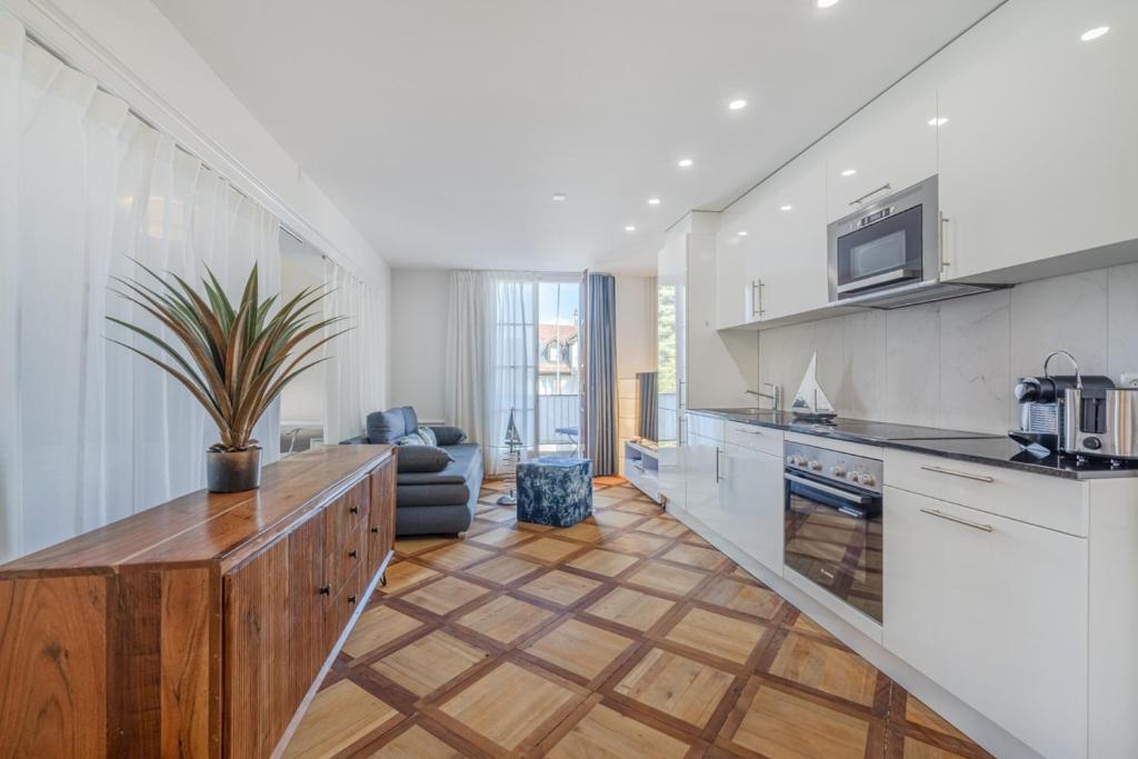 een keuken met witte kasten en een houten aanrechtblad bij Aparthotel Mama Home Stankt Georgen in St. Gallen