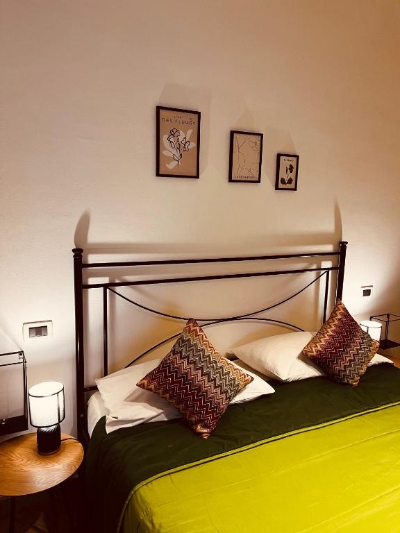 a bedroom with a green bed with pillows on it at Sicilia Vacation rooms in Trapani