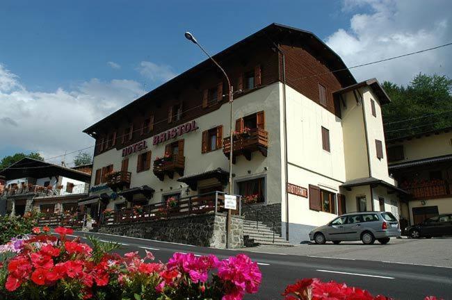 a building on the side of a street with flowers at Hotel Bristol in Fiumalbo