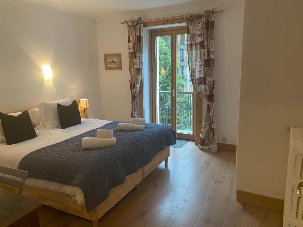 une chambre avec un grand lit avec deux oreillers dessus dans l'établissement Appartement Le Lutetia, à Chamonix-Mont-Blanc