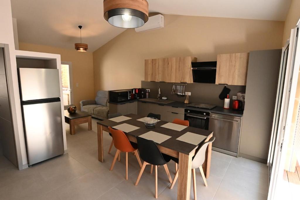 une cuisine et une salle à manger avec une table et des chaises dans l'établissement Gîte le pontilh, à Saint-Privat