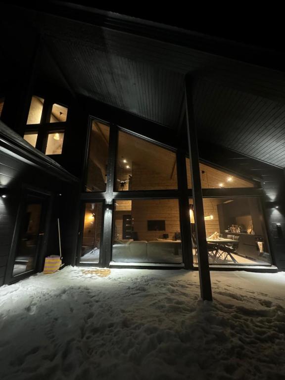 a building with a large window in the snow at Villa Outi, a Luxurious Villa in Äkäslompolo, Lapland in Äkäslompolo