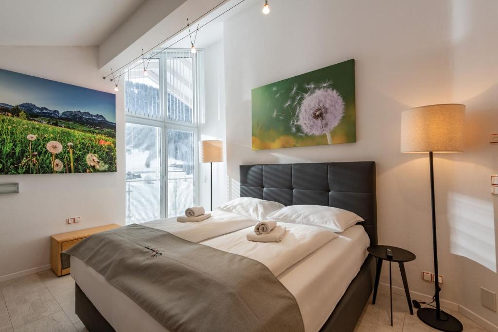 a bedroom with a large bed and a large window at Ferienhaus Au Villa in Söll