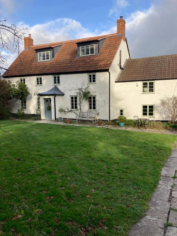 a large white house with a lawn in front of it at Blindwell House in Nether Stowey