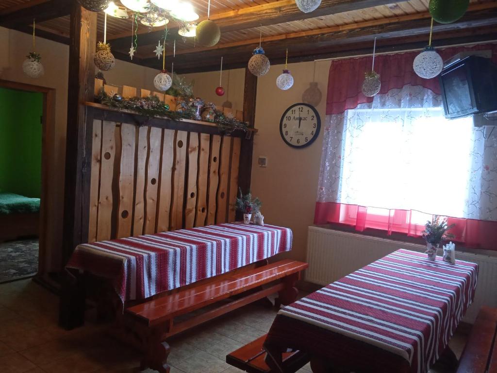 pokój z dwoma łóżkami, oknem i zegarem w obiekcie Червона Калина w Sławsku