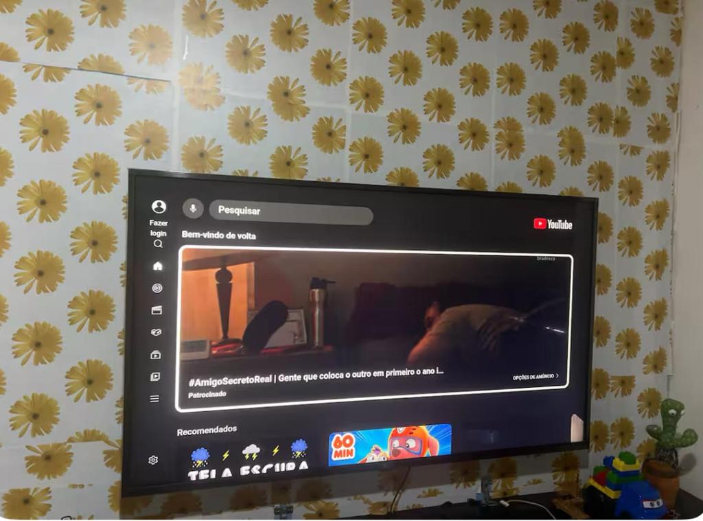 einem Computermonitor mit Bild einer Person an der Wand in der Unterkunft Melhor Custo BENEFICIO DO RECIFE in Recife