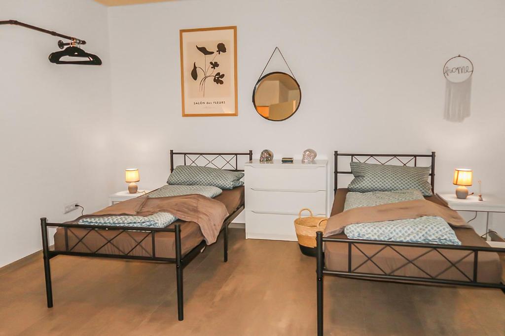 two twin beds in a room with a mirror at Helle geräumige 80 qm Wohnung - 5 min von Friedberg - Self Check-In in Bruchenbrücken