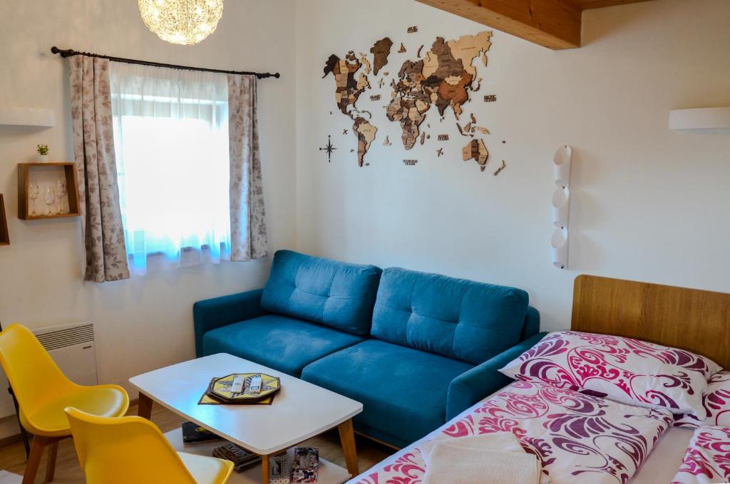 a living room with a blue couch and a table at Apartmán Hejč in Moravská Nová Ves