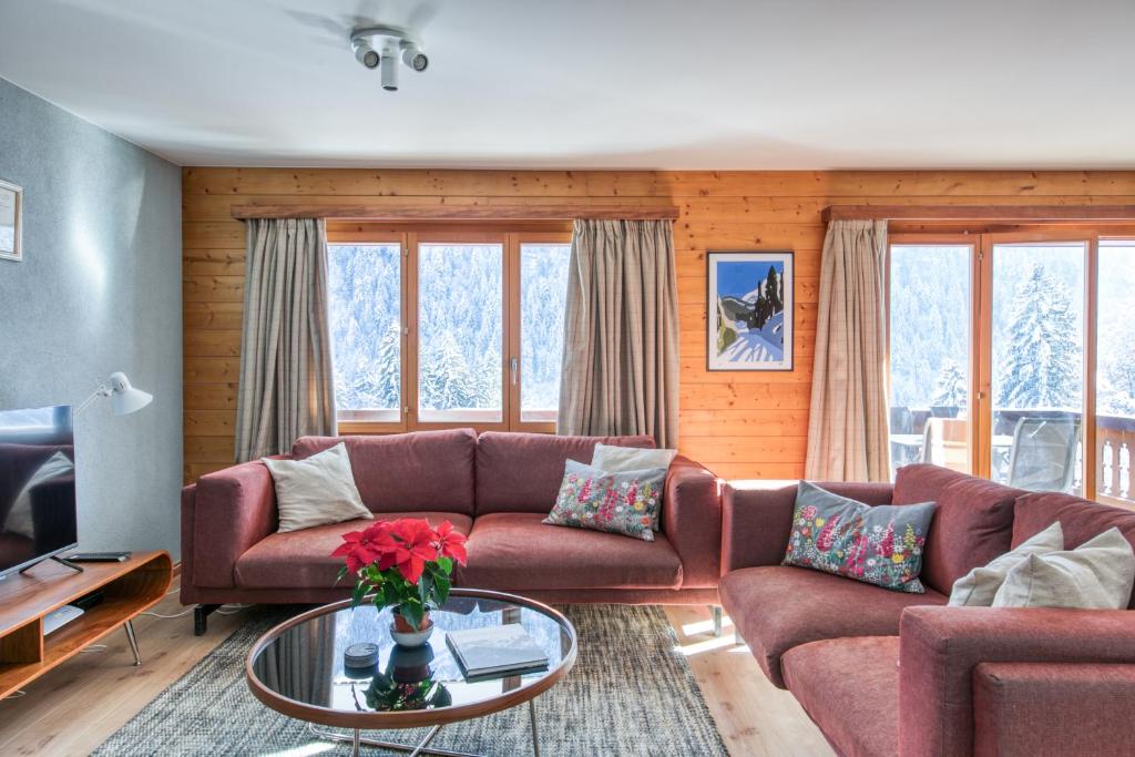 a living room with a couch and a table at Champcalme 5 and its exclusive views in Champéry