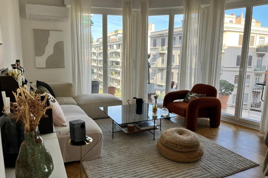 un salon avec un canapé, des chaises et des fenêtres dans l'établissement Cozy T3 with Wifi in the heart of Vauban, à Marseille