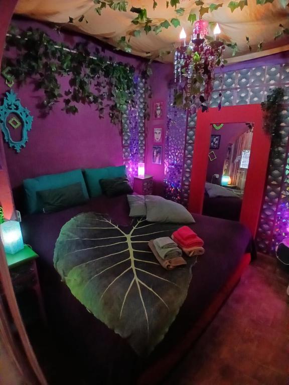 a bedroom with a large bed with purple walls at MAISONETTE Fata Bislacca, calcata in Calcata