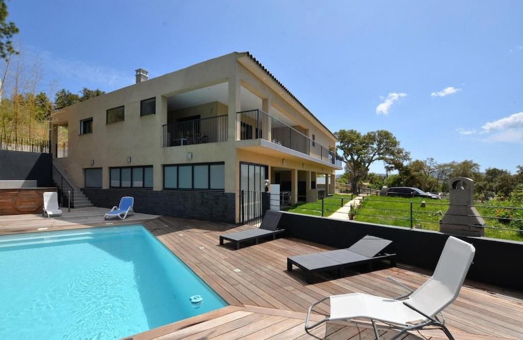 une maison avec une piscine devant une maison dans l'établissement CasaNota Haut de villa 200m2 avec piscine privée, à Porto-Vecchio