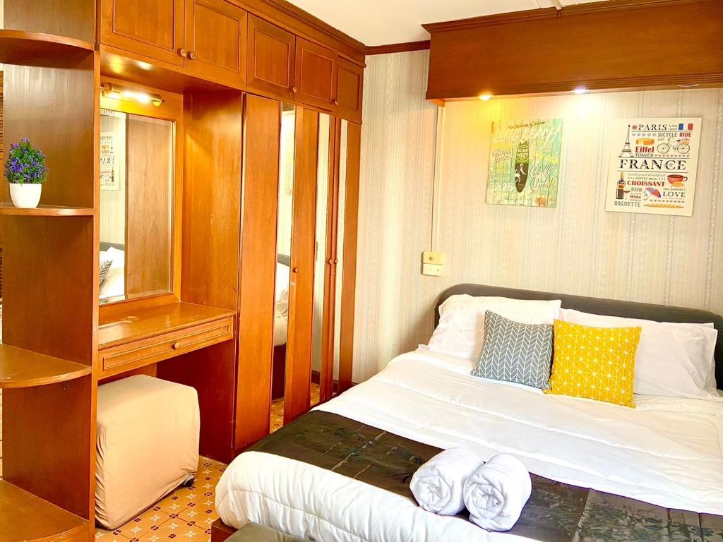 a bedroom with a bed and a wooden cabinet at Impact Arena Condo The Classic by GoodRoom24 in Ban Song Hong