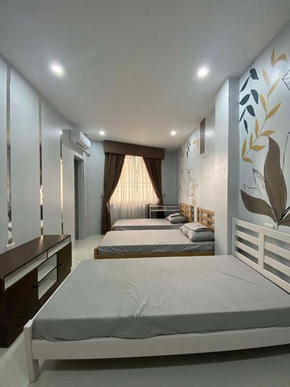 a large bedroom with two beds and a window at Ciudad Esperanza near Davao Airport in Davao City