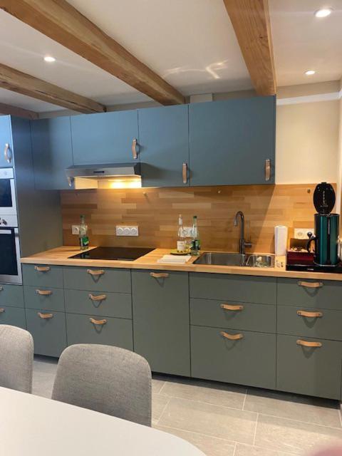 une cuisine avec des armoires bleues et un évier dans l'établissement village house, à Val Cenis