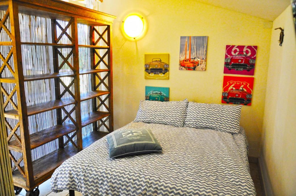 sypialnia z łóżkiem i zdjęciami na ścianie w obiekcie Holiday Apartments Fiumetto w mieście Marina di Pietrasanta