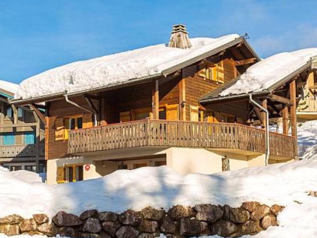 une grande maison en bois avec de la neige sur le toit dans l'établissement Chalet spacieux avec Wi-Fi et parking privé aux Gets - FR-1-671-141, aux Gets