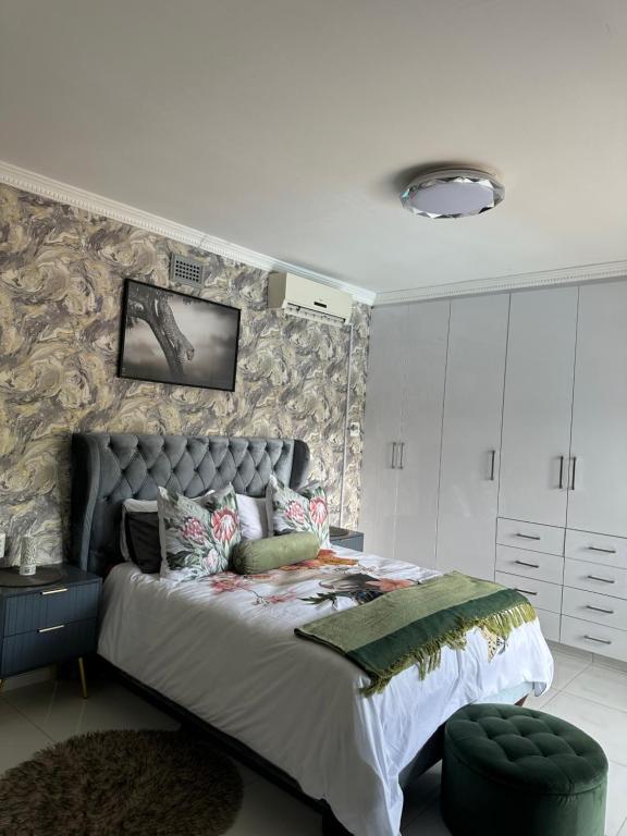 a bedroom with a large bed and a wall at The Azania Lux in Durban