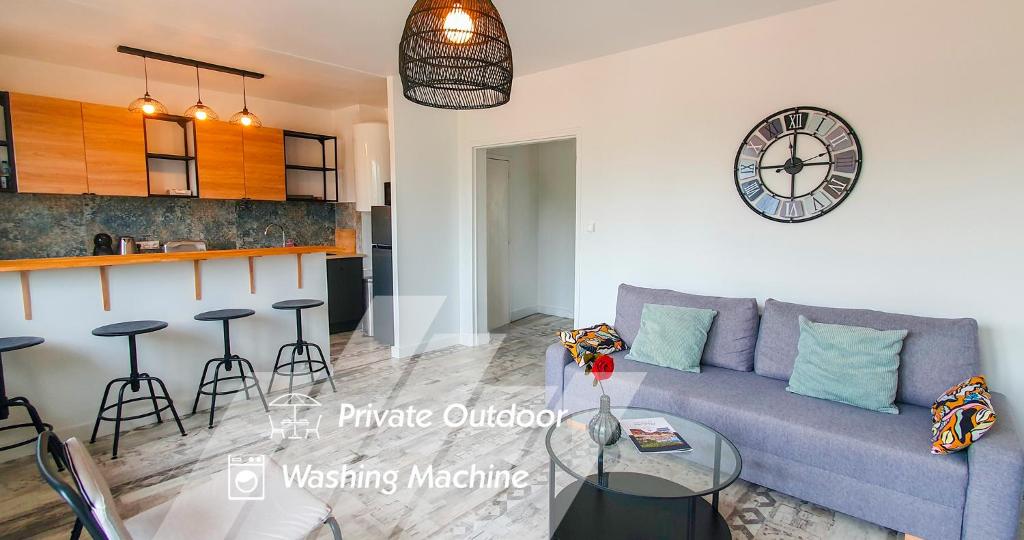 un salon avec un canapé et une horloge au mur dans l'établissement Terrace - Quiet - Near ramparts, à Avignon