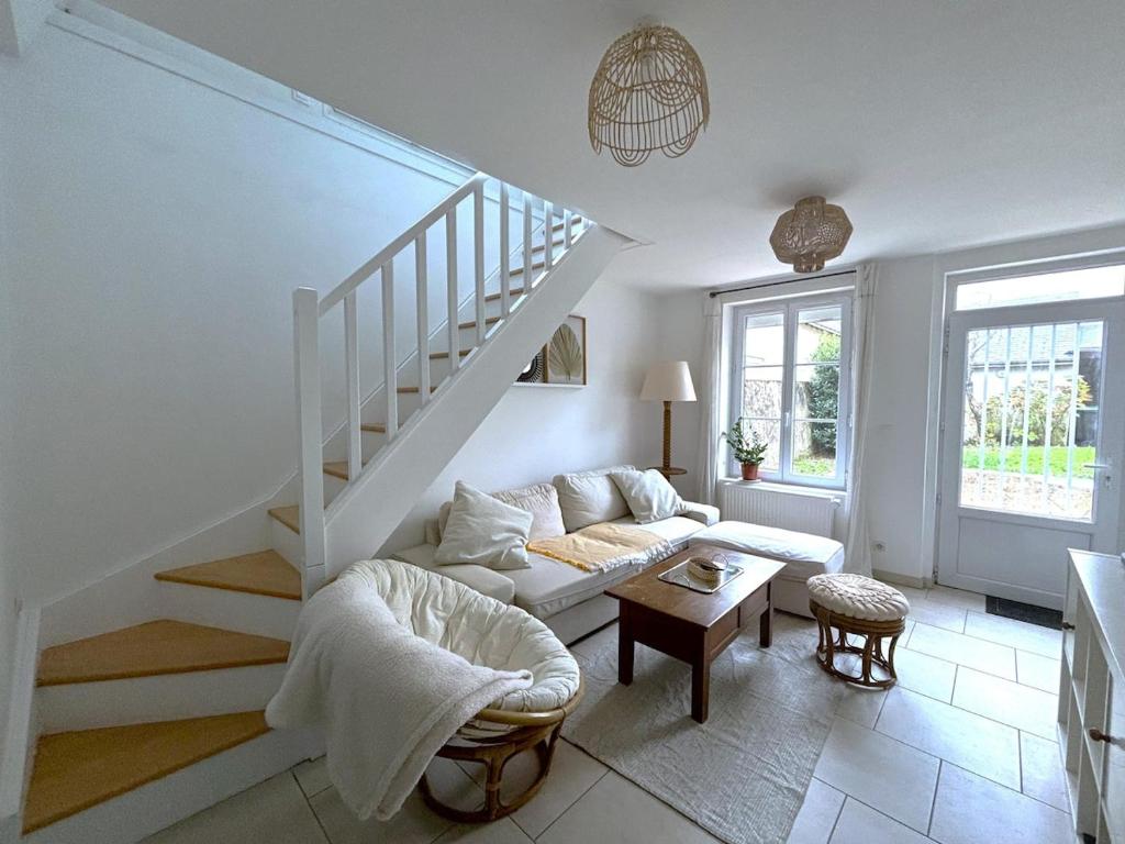 un salon avec un escalier et un canapé dans l'établissement Au charme Amboisien, maison centre ville avec jardin, à Amboise