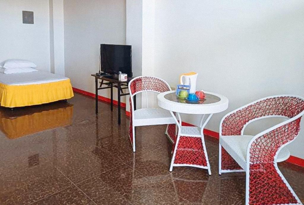 a room with a table and chairs and a table and a tv at MBU Suites Bed n Breakfast RedPartner in Guiguilonen