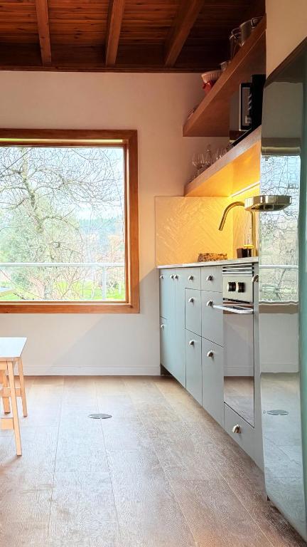 uma cozinha com uma grande janela e um fogo em Casa do Rio Alva em Arganil
