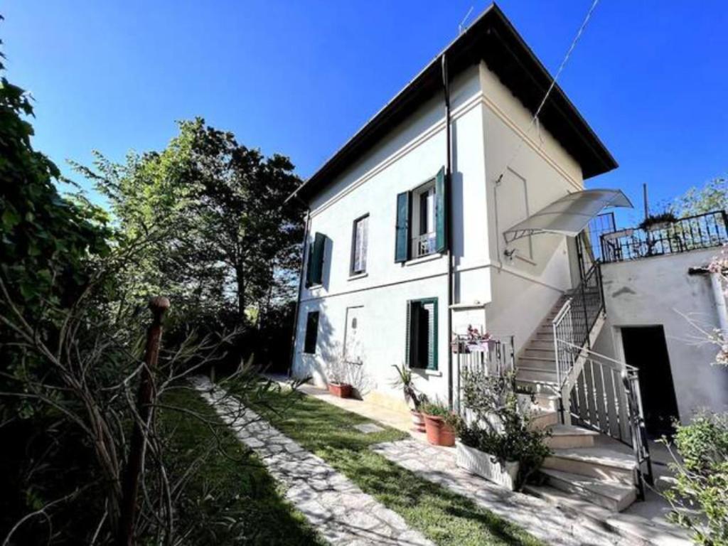 a white house with a staircase leading up to it at Villa San Cataldo primo piano in Modena